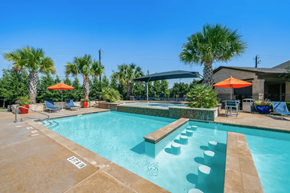 Pasadena apartment for rent - A pool with a water slide and a few chairs.