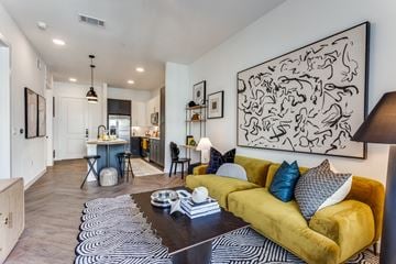 Fort Worth apartment for rent - A living room with a yellow couch and a black and white abstract painting on the wall.