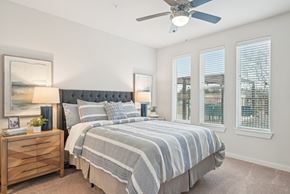 Rockwall apartment for rent - A bedroom with a large bed and a ceiling fan.