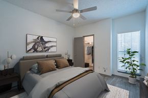 Dallas apartment for rent - a bedroom with a large bed and a ceiling fan