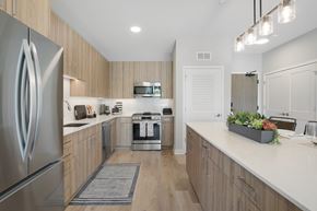 Skokie townhouse for rent - A modern kitchen with a stainless steel refrigerator and wooden cabinets.