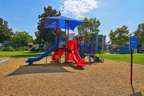Ontario apartment for rent - A playground with a blue umbrella and a red slide.