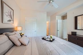 Doraville apartment for rent - A bedroom with a large bed and a ceiling fan.