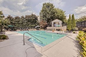 Doraville apartment for rent - A large outdoor swimming pool surrounded by trees and a gazebo.
