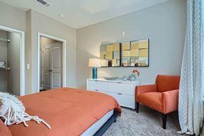 Atlanta apartment for rent - A bedroom with a bed, chair, and lamp.