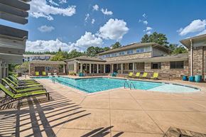 Atlanta apartment for rent - A swimming pool surrounded by lounge chairs and a building in the background.