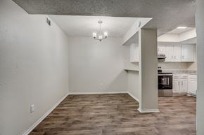 Dallas apartment for rent - an empty living room with a kitchen in the background