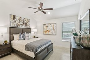 Harker Heights townhouse for rent - A bedroom with a large bed and a ceiling fan.