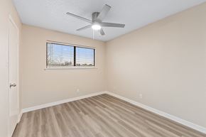 Dallas apartment for rent - an empty bedroom with a ceiling fan and a window