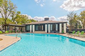 Houston apartment for rent - A swimming pool in front of a house with a sunny sky.