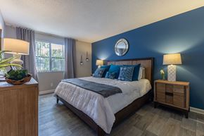 North Lauderdale apartment for rent - A bedroom with a large bed and a wooden nightstand.