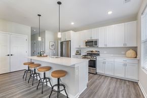 Crystal Lake apartment for rent - A kitchen with white cabinets and a bar area with stools.