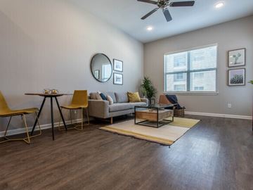 Spring apartment for rent - A living room with a yellow chair and a beige couch.