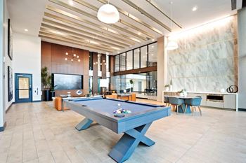 Indoor resident lounge with tvs, pool table and coffee bar