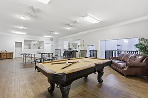 Stephenville apartment for rent - A pool table is in the middle of a room with a couch and chairs.