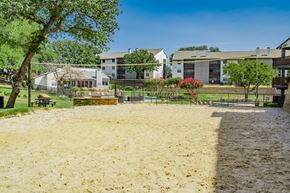 Arlington apartment for rent - a sandy playground with buildings in the background and trees