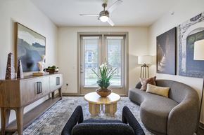 Georgetown apartment for rent - A living room with a grey couch, a wooden table, and a ceiling fan.