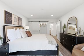 Jackson apartment for rent - A bedroom with a large bed and a dresser with a mirror.