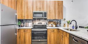 Fort Worth apartment for rent - A kitchen with wooden cabinets and a stainless steel refrigerator.