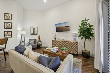 Mckinney apartment for rent - A living room with a beige couch, a wooden coffee table, and a painting on the wall.