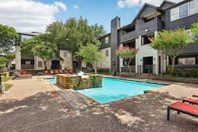 Dallas apartment for rent - A swimming pool surrounded by a patio and buildings.