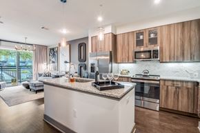 Dallas apartment for rent - A modern kitchen with wooden cabinets and stainless steel appliances.