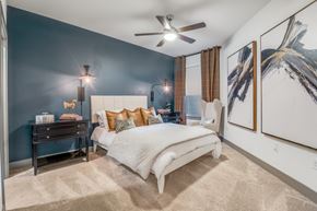 Dallas apartment for rent - A bedroom with a bed, nightstand, and a ceiling fan.