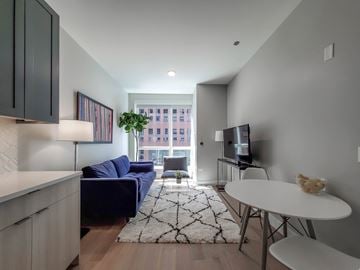Chicago apartment for rent - A living room with a blue couch and a television.