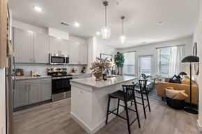 Fort Worth apartment for rent - A modern kitchen with a large island and bar stools.