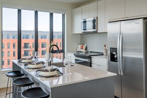 Durham apartment for rent - a kitchen with a island and stainless steel appliances and a large window