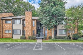 Atlanta apartment for rent - A brick building with a parking lot in front.