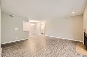 Atlanta apartment for rent - A spacious room with wood flooring and a doorway leading to another room.