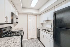 Atlanta apartment for rent - A kitchen with black appliances and white cabinets.