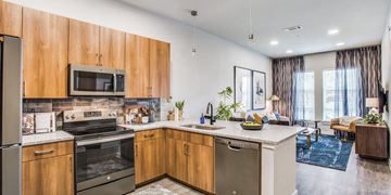 Fort Worth apartment for rent - A modern kitchen with wooden cabinets and stainless steel appliances.