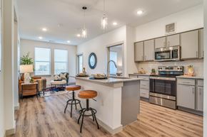 Melissa apartment for rent - A modern kitchen with a bar stool and a countertop.
