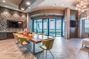 Fort Worth apartment for rent - A modern dining room with a long table and yellow chairs.
