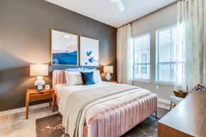Fort Worth apartment for rent - A bedroom with a large bed and a painting on the wall.