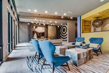 Fort Worth apartment for rent - A modern living room with blue chairs and a patterned rug.