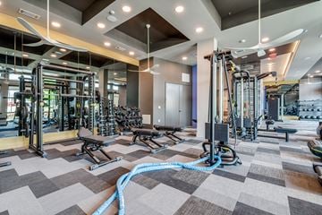 Fort Worth apartment for rent - A gym with a variety of equipment including treadmills, weights, and exercise machines.