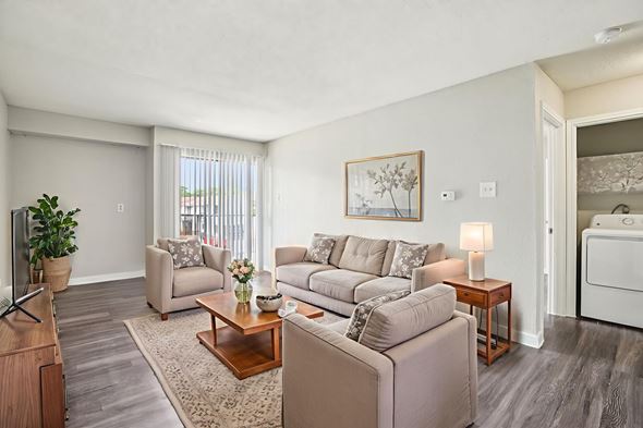 Austin apartment for rent - A living room with a couch, chair, and a table with a vase of flowers on it.