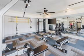 Charlotte apartment for rent - A gym with a variety of equipment including weights and a bench.