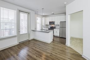 Charlotte apartment for rent - A kitchen with white cabinets and a wooden floor.