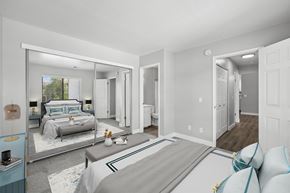Rocklin apartment for rent - A bedroom with a large bed and a mirrored wall.