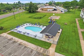 Stephenville apartment for rent - A pool with a slide and a building in the background.
