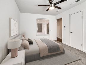 Oklahoma City apartment for rent - A bedroom with a bed, nightstand, and a ceiling fan.