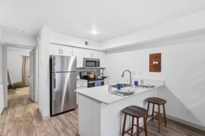 Fort Worth apartment for rent - A kitchen with a refrigerator, microwave, and stove top oven.