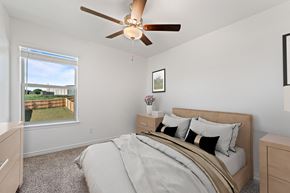 Harker Heights townhouse for rent - A bedroom with a large bed and a ceiling fan.