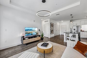 Atlanta apartment for rent - A modern living room with a large television and a coffee table.