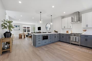 Skokie townhouse for rent - A modern kitchen with a wooden floor and grey cabinets.