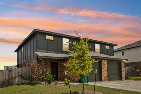 Harker Heights townhouse for rent - A modern house with a grey roof and a tree in front.